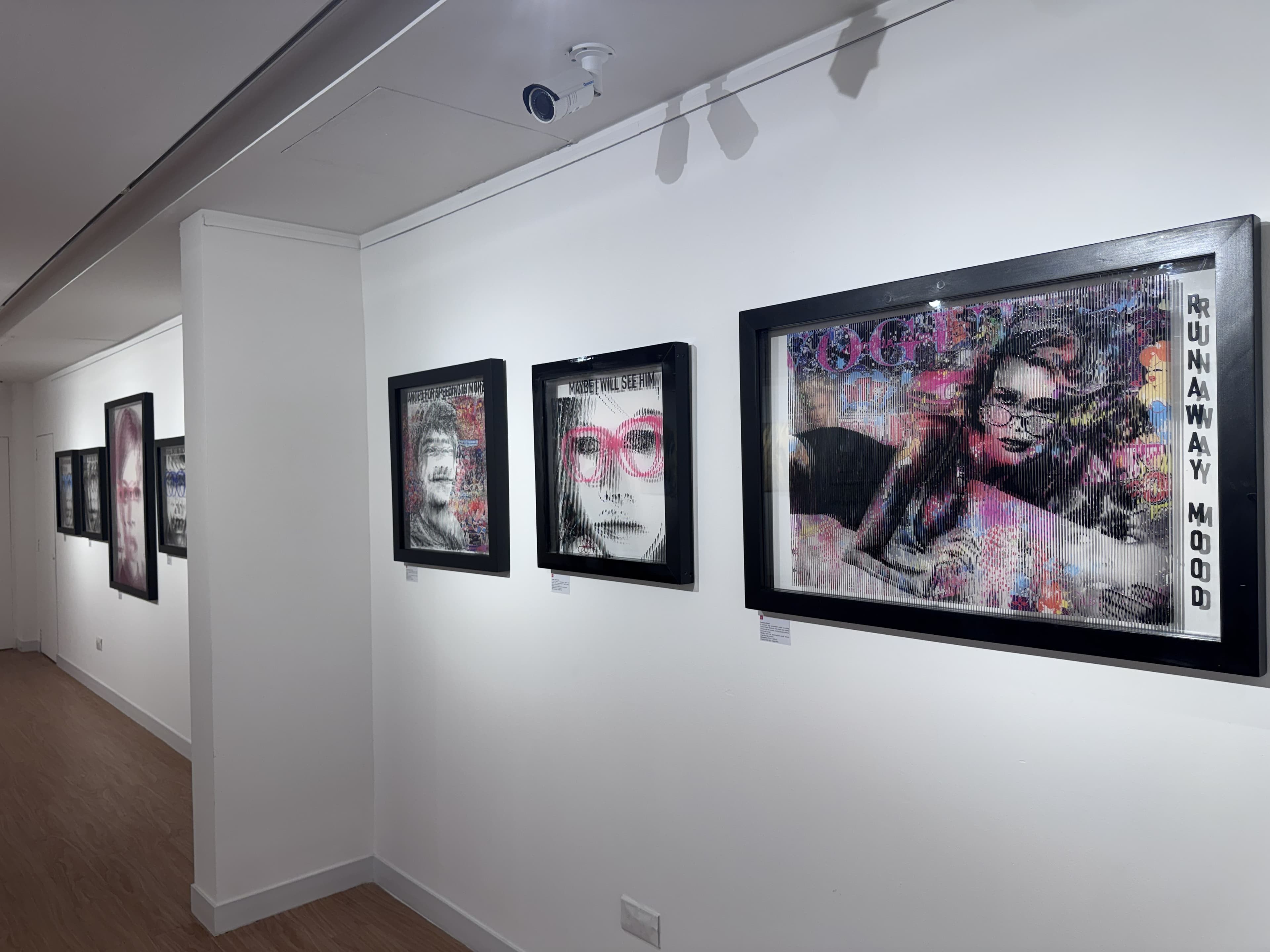 Œuvres de Fabian PhiL, dont Runaway Mood, accrochées le long du mur de la galerie dans Beyond the Gaze